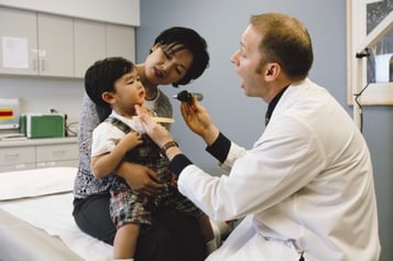doctor giving asian child routine check up