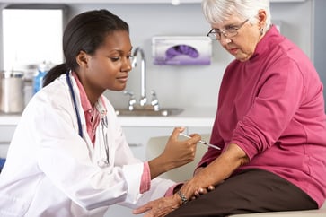 doctor giving senior female patient an injection