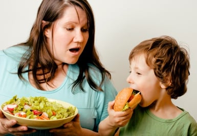 mom with salad and son with hamburger