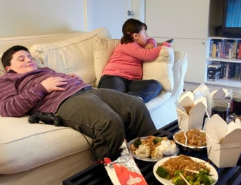 overweight kids eating takout on couch